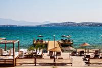 een steiger met stoelen en parasols op het water bij Nars Ilica Hotel Beach Adults Only 12Plus in Çeşme