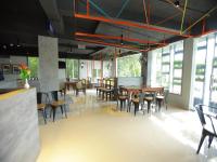 カンヌールにあるWithInn Hotel - Kannur Airportのテーブルと椅子と窓のあるダイニングルーム