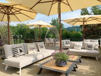SchmerikonにあるStrandhotel Schmerikonのパティオ(ソファ、パラソル付)