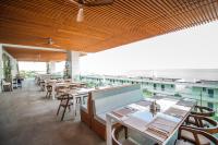 White Lagoon Resort - All Inclusive في كافارنا: مطعم مع طاولات وكراسي وإطلالة على المحيط