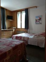 a hotel room with two beds and a window at Hotel Val Joly in Saint-Gervais-les-Bains