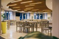 Un restaurante con mesas y sillas de madera y ventanas. en Maran Suites & Towers, en Paraná