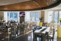 Un comedor con mesas y sillas y ventanas. en Maran Suites & Towers, en Paraná