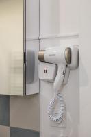 a hair dryer hanging from a wall in a bathroom at Proche Paris, Confort, Wifi, Netflix in Deuil-la-Barre