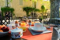 a table with cups and bowls of eggs and fruit at Hôtel Mas Valentine in Saint-Rémy-de-Provence