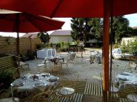 um grupo de mesas e cadeiras com guarda-sóis em Le Piano em Biesles