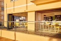 een balkon met stoelen en tafels op een gebouw bij First Group Riviera Suites in Kaapstad