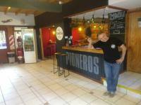 um homem parado em um bar em um restaurante em Del Glaciar Libertador Hotel em El Calafate