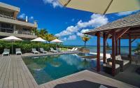 una piscina en un resort con sillas y sombrillas en Bon Azur Beachfront Suites &amp; Penthouses with LOV, en Trou aux Biches