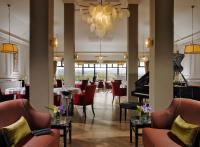 ウェストポートにあるKnockranny House Hotel & Spaの赤い椅子とピアノのあるレストラン