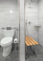 a bathroom with a toilet and a wooden bench at Artezen Hotel in New York