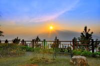a bench in front of a fence with the sunset at Jun Yue Hanging Garden Resort in Ren&#39;ai