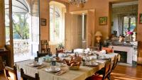 a dining room with a long table with chairs and a fireplace at B&amp;B Château de Preuil in Vallenay