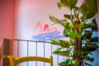 a plant sitting next to a crib with a painting on the wall at The Melegran in Rovinj