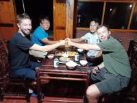 a group of men sitting around a table holding hands at My's Homestay sapa in Sa Pa