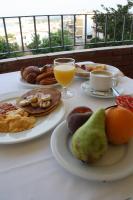 Hotel Grecs في روساس: طاولة مع أطباق من طعام الإفطار وكوب من عصير البرتقال