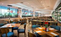 ein Restaurant mit Holztischen und blauen Stühlen in der Unterkunft Lagoona by Isrotel Collection in Eilat