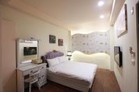 a bedroom with a white bed and a mirror at Fasiter B&amp;B train station in Hualien City