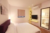 a bedroom with a bed and a mirror and a sink at Fasiter B&amp;B train station in Hualien City