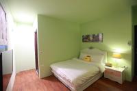 a green bedroom with a bed with a stuffed animal on it at Fasiter B&amp;B train station in Hualien City