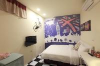 a bedroom with a bed and a wall with a mural at Fasiter B&amp;B train station in Hualien City