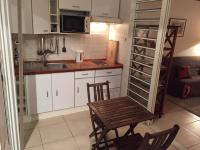 a small kitchen with a table and chairs and a wine cellar at BAY VIEW MARTINIQUE in Les Anses-dʼArlets