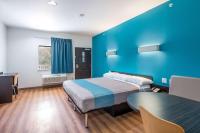 Un dormitorio con una cama y una pared azul. en Motel 6-Channelview, TX, en Channelview