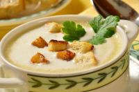 Hotel Gasthof Jägerhaus في سانكت بيتر: وعاء من الحساء مع قطع الخبز المحمص والنعناع في الأعلى