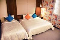 a bedroom with two beds with colorful pillows at Golden Tulip Glory Fine Hotel in Tainan