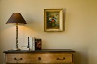 a lamp on a dresser with a picture of flowers at Villa des Groseilliers Spa Practice golf moutons in Loison-sur-Créquoise