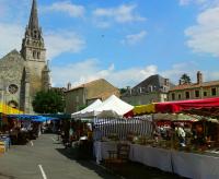an outdoor market in front of a church with a tower at Thunder Roadhouse in La Mothe-Saint-Héray