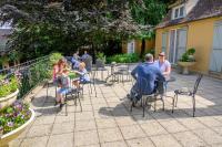 a group of people sitting at tables in a patio at B&amp;B Au bois dormant chambres d hotes in Tillé