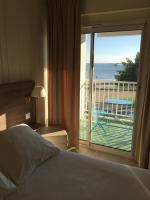 a bedroom with a bed and a view of the ocean at Hôtel Beau Rivage in Royan