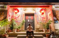 a man sitting on steps in front of a building at I-Shan B&amp;B in Jincheng