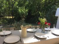 a table with plates and glasses and a vase with flowers at Serendip in Avignon