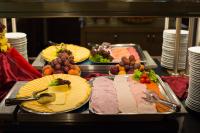 Un buffet con muchos tipos diferentes de carnes y quesos. en CE Plaza Hotel, en Siófok