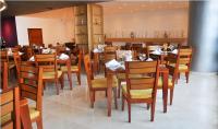 uma sala de jantar com mesas e cadeiras de madeira em Hotel Atrium Plaza em Barranquilla