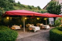 a patio with tables and chairs under a red umbrella at Landhaus Keller - Hotel & Restaurant in Malterdingen