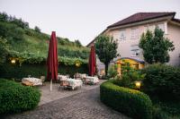 a patio with tables and red umbrellas and a building at Landhaus Keller - Hotel & Restaurant in Malterdingen