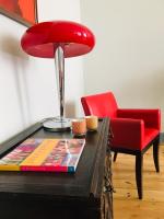 a red chair and a table with a red lamp at LES CHAMBRES D&#39;HOTES DU PALAIS in Douai
