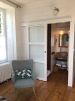 a room with a chair and a sliding door at Tilleuls et Bambous in Saint-Sauveur-dʼAunis