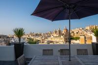 a patio with an umbrella and a view of the city at Penthouse Retreat in Cospicua