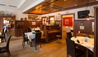 Un restaurante con mesas y sillas en una sala. en Hotel Gasthof König, en Kremsmünster