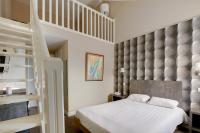 a bedroom with a loft bed and a staircase at Hôtel Arcadia in Lannion
