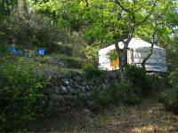 a white trailer parked in a field with two chairs at Le Mas Nomade in Callian
