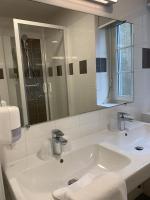 a white bathroom with a sink and a mirror at Hôtel de la Gare - Restaurant Bistro Quai in La Roche-sur-Yon