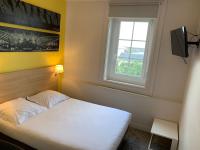 a bedroom with a white bed and a window at Hôtel de la Gare - Restaurant Bistro Quai in La Roche-sur-Yon
