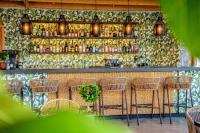 un bar con sillas de mimbre y una barra con botellas en Creta Blue Boutique Hotel, en Hersonissos