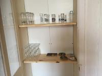 a shelf with glasses on it in a room at Maison de ville 3 chambres 3 salles d&#39;eau parking 2 places in Romorantin