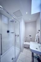 a white bathroom with a shower and a sink at Maison Nô - Hôtel et Rooftop in Lyon
